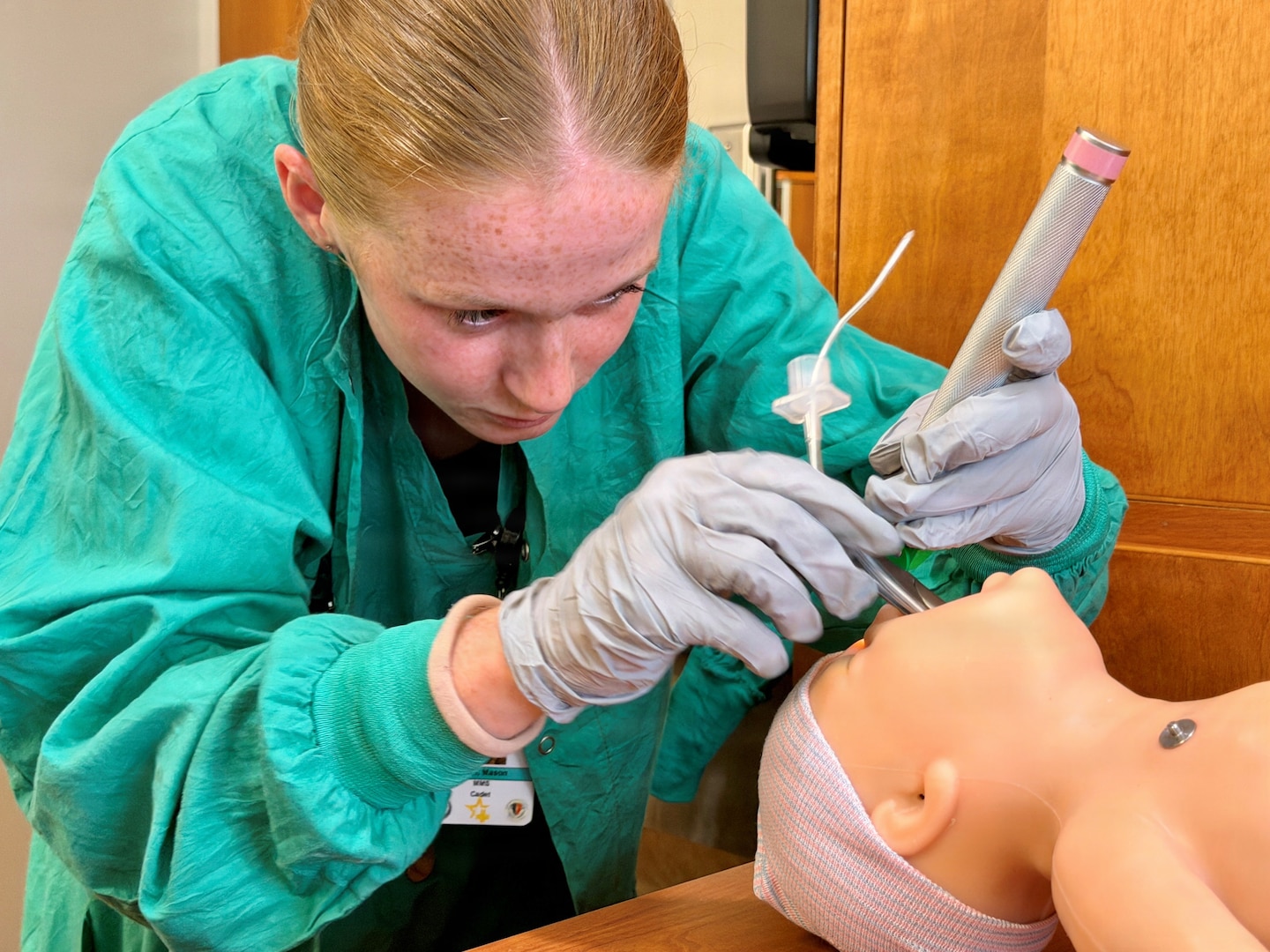 Nurse cadet practices keeping a neonatal airway open.