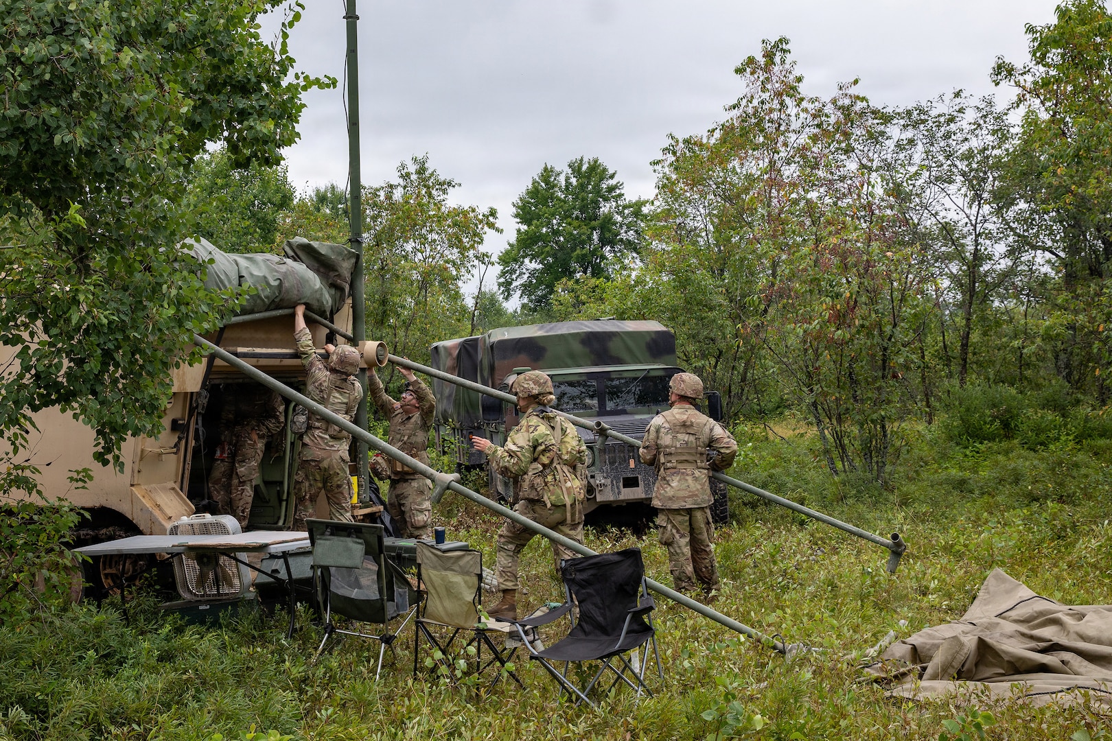 U.S. Army Soldiers assigned to A Battery, 1st Battalion, 201st Field Artillery Regiment, West Virginia Army National Guard, set up an OE-254/GRC ground antenna system in preparation for a fire mission during Exercise Northern Strike 26-2 in Michigan, Aug. 5, 2026.