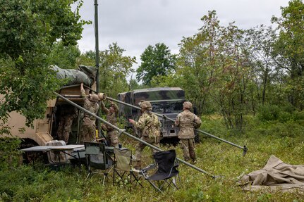 U.S. Army Soldiers assigned to A Battery, 1st Battalion, 201st Field Artillery Regiment, West Virginia Army National Guard, set up an OE-254/GRC ground antenna system in preparation for a fire mission during Exercise Northern Strike 26-2 in Michigan, Aug. 5, 2026.