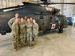 Group of Nursing Cadets poses for a group photo in front of a Medevac helicopter.
