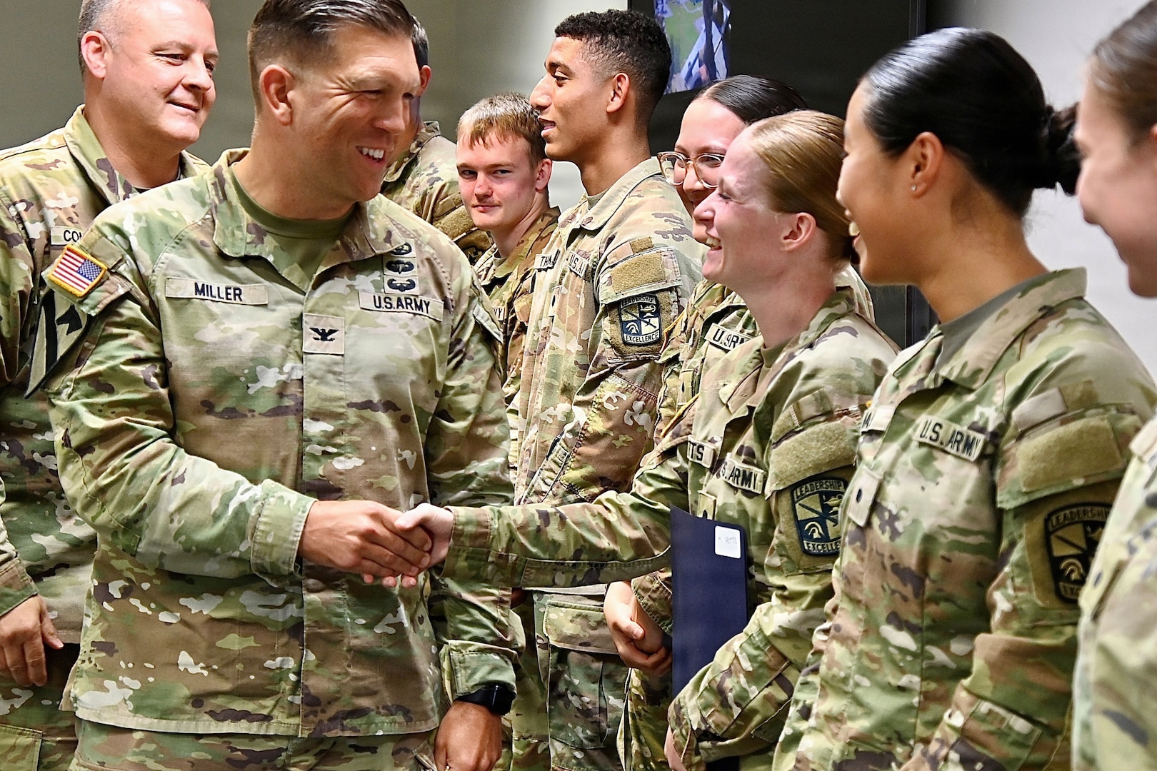 The Hospital Commander walks in front of a line of Soldiers, shaking their hands in congratulation.