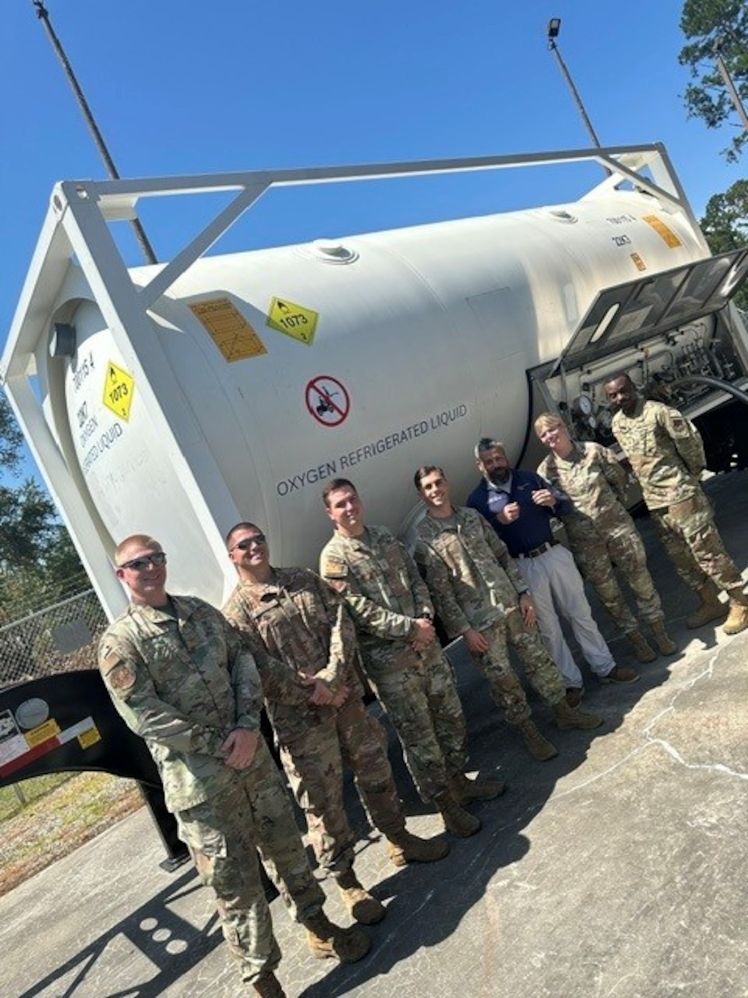 23d LRS Airmen posing next to liquid oxygen tank
