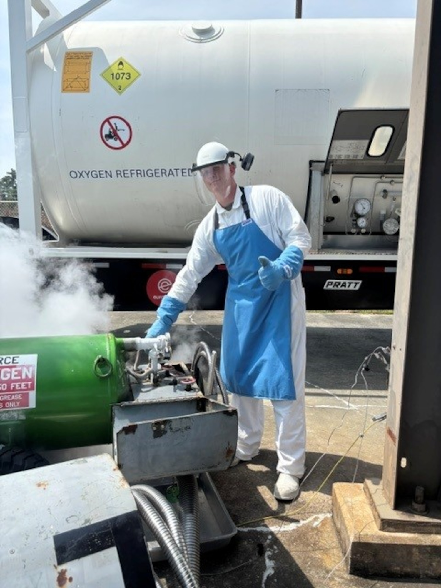 Airman posing next to a liquid oxygen tank