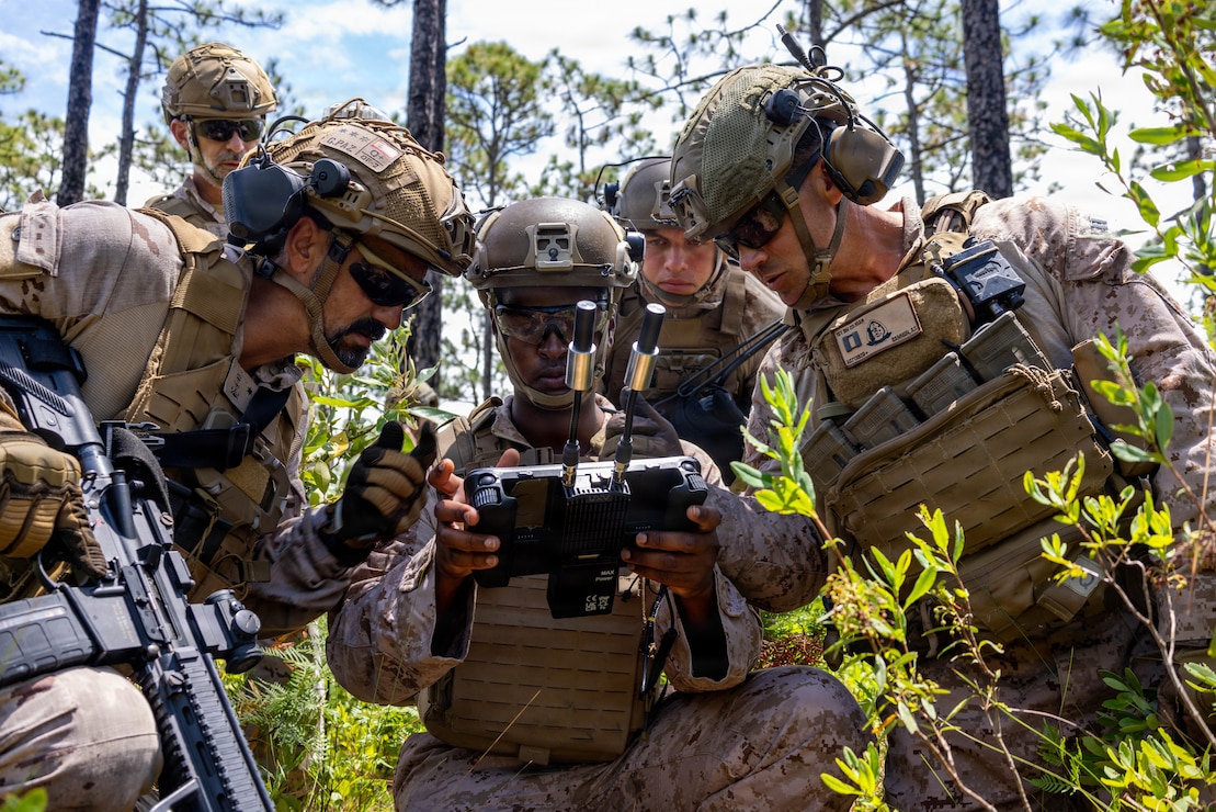 U.S. Marine Corps Sgt. Idris Idris, center, a small unmanned aircraft systems specialist with U.S. Marines with 1st Battalion, 2nd Marine Regiment, 2nd Marine Division, demonstrates the C100 drone capabilities to a Spanish marine during a company live-fire range as a part of Fleet Exercise 250 (FLEETEX) on Marine Corps Base Camp Lejeune, North Carolina, June 19, 2026. FLEETEX 250 represents the United States’ commitment to layer defense of the homeland through forward-deployed forces and reinforces interoperability with allies and partners through collective maritime security. (U.S. Marine Corps photo by Cpl. Channah Chilton)
