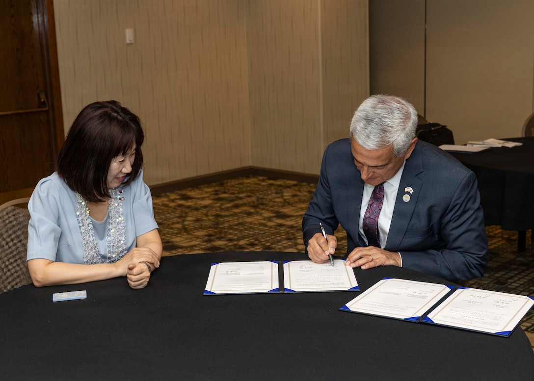 Kang Yunjin, Vice Minister of Republic of Korea Ministry of Patriots and Veterans Affairs, and Kelly McKeague, director of the Defense POW/MIA Accounting Agency, sign a memorandum of understanding at the Korean/Cold War Annual Government Briefing in Omaha, Nebraska, Aug. 7, 2026.