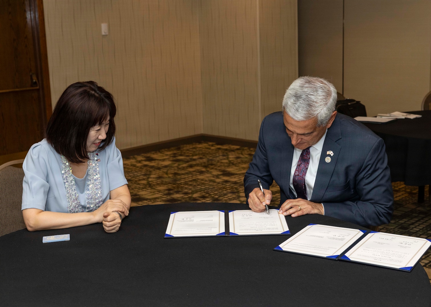 Kang Yunjin, Vice Minister of Republic of Korea Ministry of Patriots and Veterans Affairs, and Kelly McKeague, director of the Defense POW/MIA Accounting Agency, sign a memorandum of understanding at the Korean/Cold War Annual Government Briefing in Omaha, Nebraska, Aug. 7, 2026.