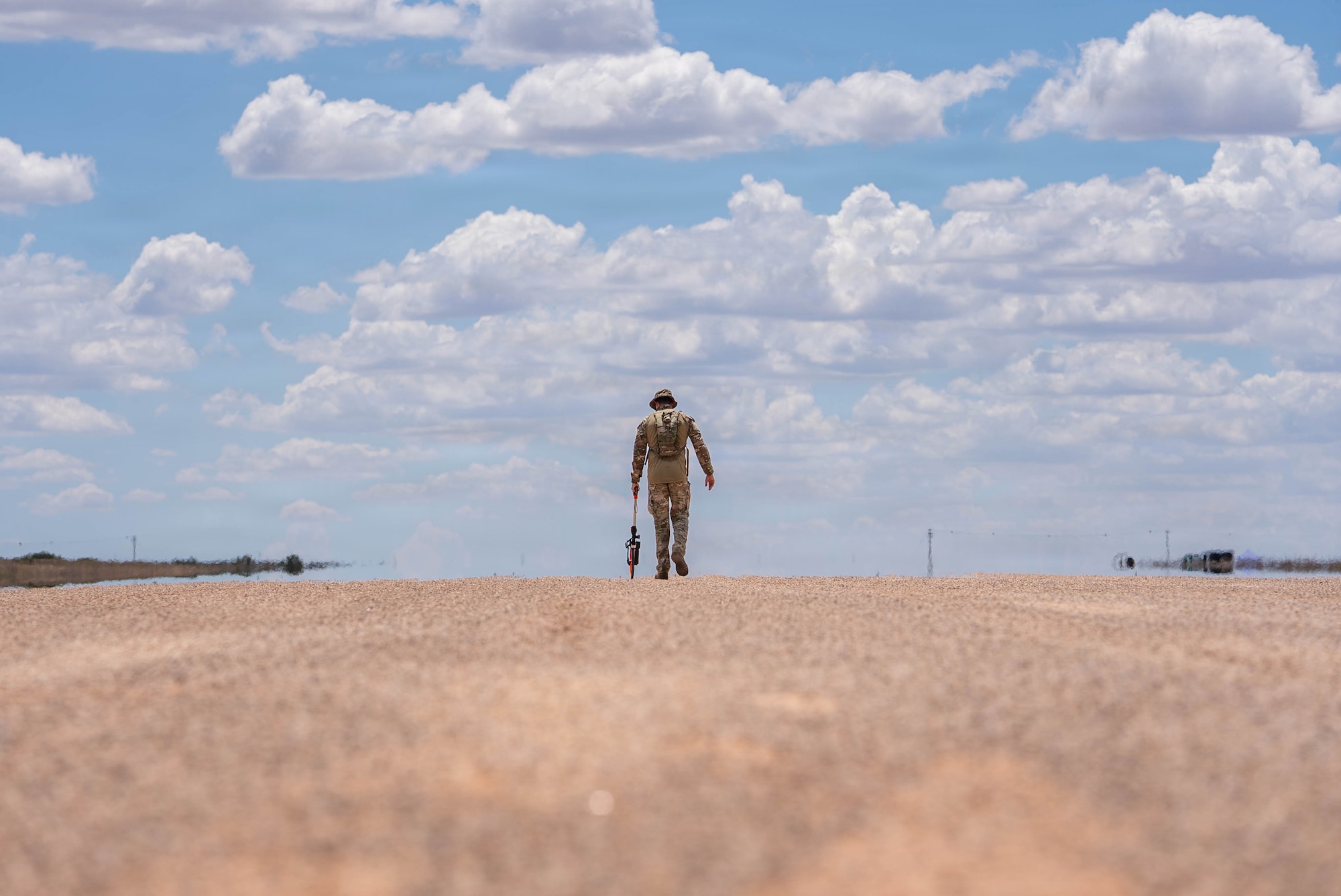 Airmen help a C-130J Super Hercules land on a dirt strip runway