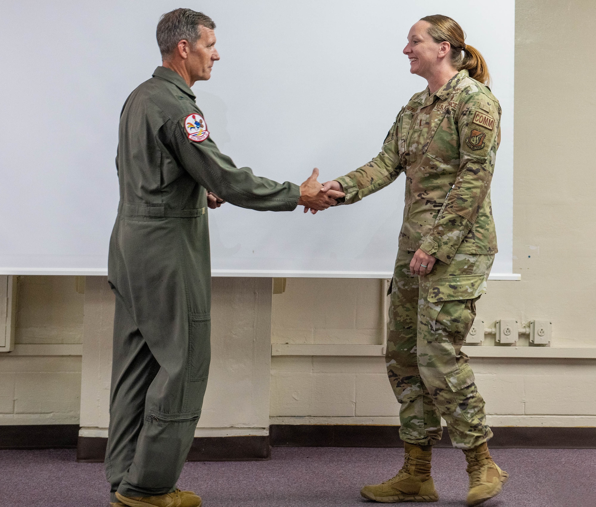 U.S. Air Force 2nd Lt. Holly Siefken, right, 18th Medical Group officer in charge of quality assurance gets coined by Brig. Gen. John Gallemore, 18th Wing commander at Kadena Air Base, Japan, July. 23, 2026. The recognition honored their actions during a medical emergency in Chatan Town, where they assisted fellow neighbors in providing lifesaving aid to a U.S. service member. (U.S. Air Force photo by Naoto Anazawa)