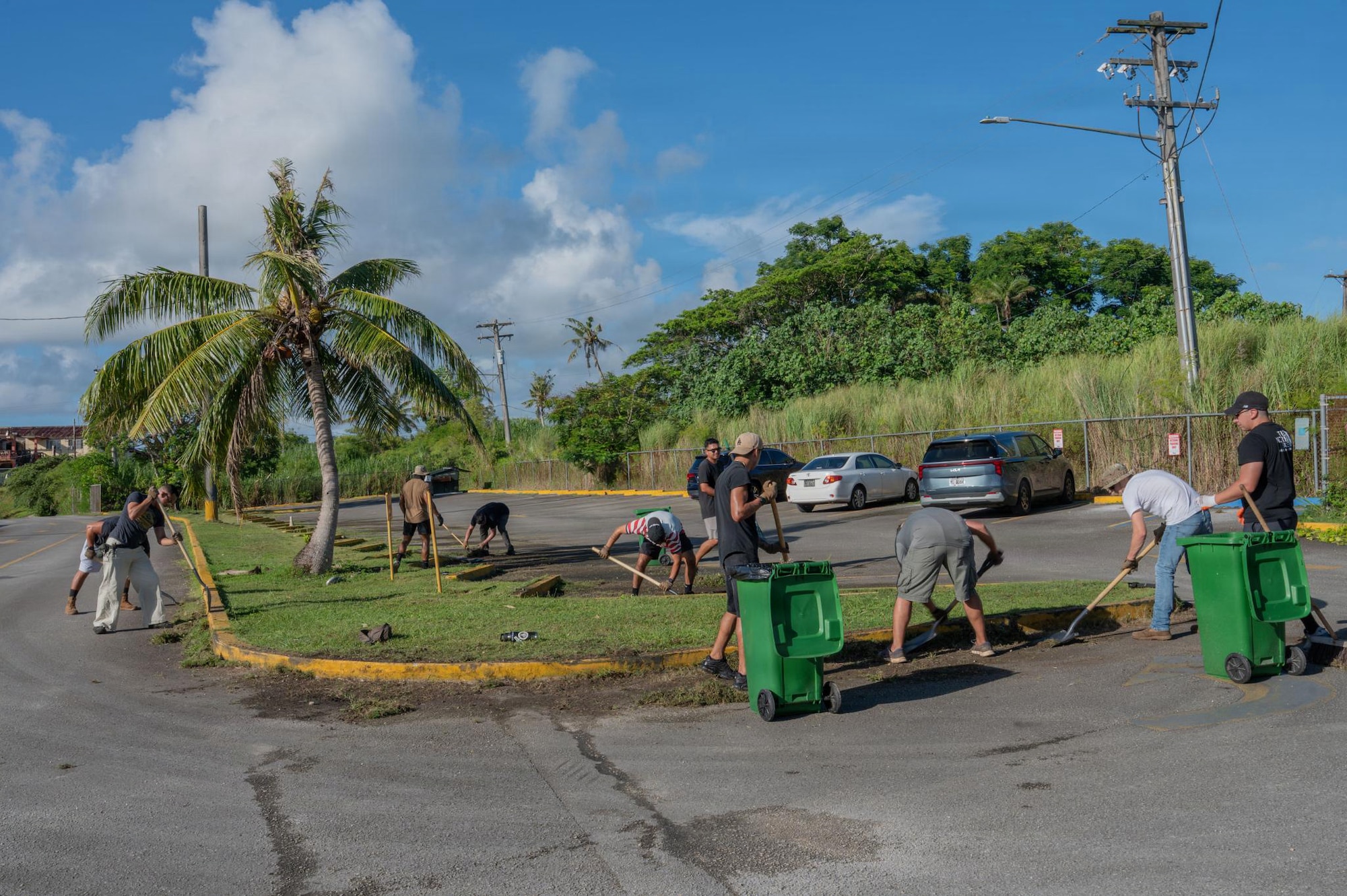 U.S. Airmen assigned to the 21st Air Task Force clear debris from a school parking lot in Mongmong-Toto-Maite, Guam, July 1, 2026. Airmen volunteered at schools across Guam to assist recovery efforts following Super Typhoon Sinlaku and prepare campuses for the return of students. (U.S. Air Force photo by Senior Airman Alondra Cristobal Hernandez)