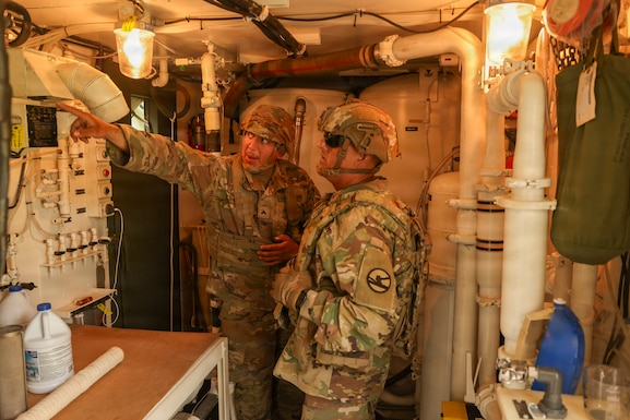Army Reserve Cpl. Emerson Villatoro, a water treatment specialist with the 250th Quartermaster Company, explains the water treatment process to Command Sgt. Maj. Freddy Trejo, CSM 84th Training Command,, August 4, 2026, at Fort McCoy, Wis. The 250th Quartermaster Company provides potable water during WAREX26.(U.S. Army Reserve photo by Sgt. 1st Class Justin Hardin)