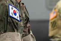 National flags are seen on the shoulders of Republic of Korea Army Brig. Gen. Woo Yang Woo, ROKA Director of the Budget and Finance Branch chief, left, and U.S. Army Command Sgt. Maj. Joy L. Allen, U.S. Army Financial Management Command senior enlisted advisor, during a visit by ROKA finance officers to USAFMCOM at the Maj. Gen. Emmett J. Bean Federal Center in Indianapolis July 9, 2026. The ROKA finance officers visited USAFMCOM after a trip to the Office of the Assistant Secretary of the Army for Financial Management and Comptroller at the Pentagon and before heading to the U.S. Army Finance and Comptroller School at Fort Jackson, S.C., where they learned about the structure and operations of the U.S. Army Finance Corps. (U.S. Army photo by Mark R. W. Orders-Woempner)