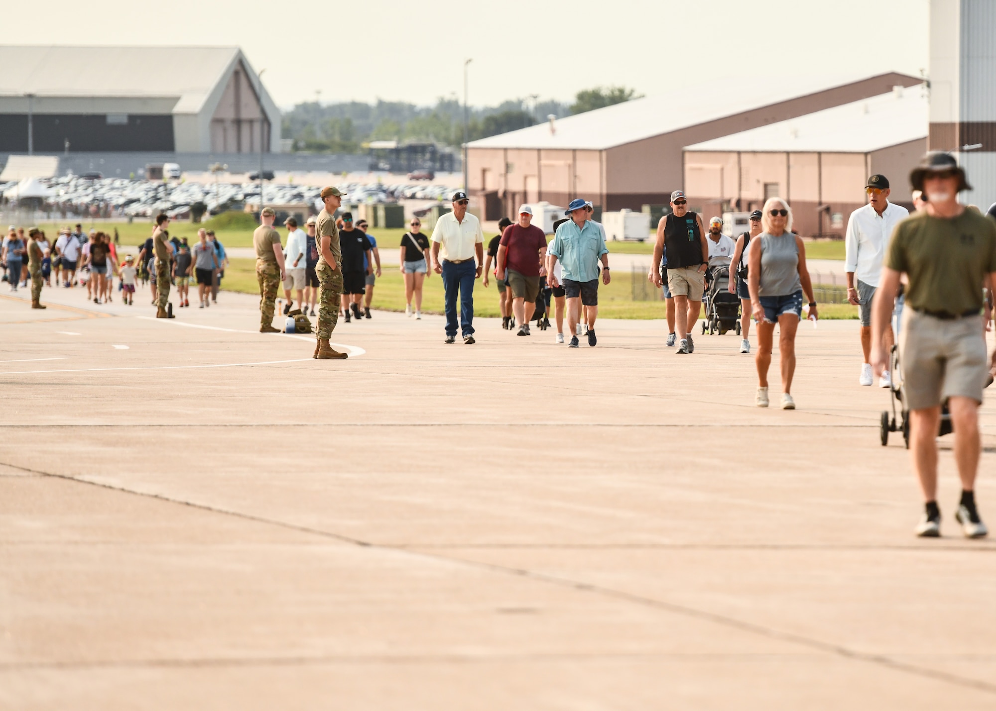 Crowds of people walk from the parking area to the entrance of the Defenders of Freedom Air & Space Show at Offutt Air Force Base, August 8, 2026. The biennial air show served as a key community outreach event, aiming to inspire the next generation of aviators by highlighting the diverse career paths and unwavering dedication of today's Airmen. (U.S. Air Force photo by Chad Watkins)