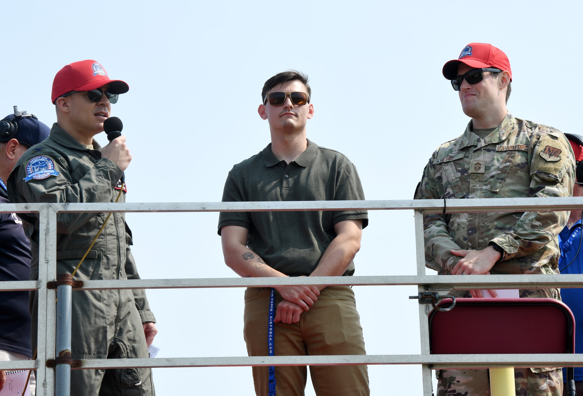Col. Aaron Gray, 55th Wing commander, and Chief Master Sgt. Alex Eudy, 55th Wing command chief, flank Airman 1st Class Charles "Air Show Alan" Bolden during the opening ceremony of the 2026 Defenders of Freedom Air & Space Show at Offutt Air Force Base, Nebraska, Aug. 8, 2026. Air Show Alan barrel rolled into the air show's social media campaign to humorously educate and hype up attendees. (U.S. Air Force photo by Charles Haymond)