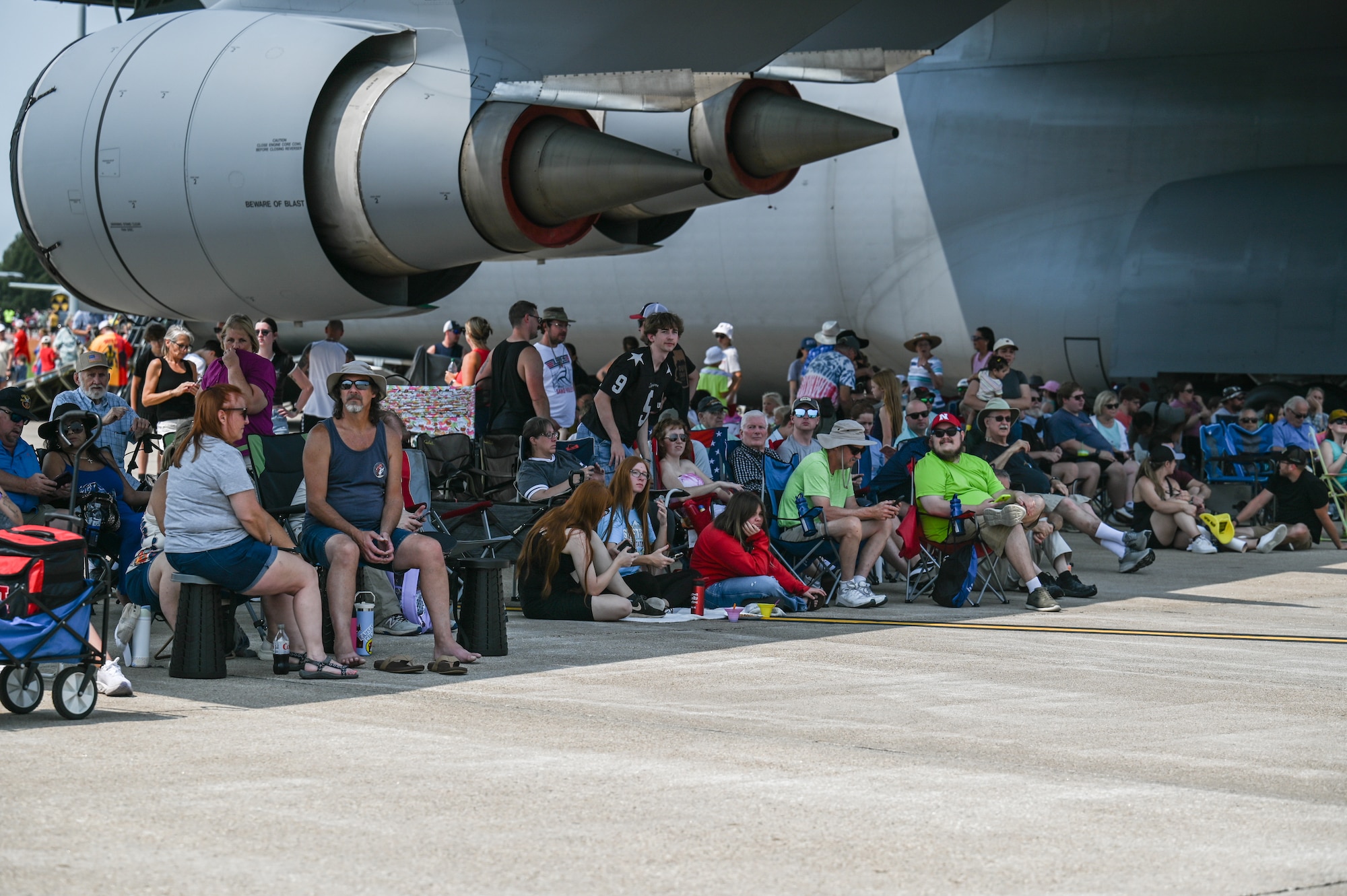 Families set up lawn chairs under the shade of the C-5M Supergalaxy to watch the afternoon aerial performances during the 2026 Defenders of Freedom Air & Space Show at Offutt Air Force Base, Nebraska, Aug. 8, 2026. The open house provided a rare opportunity for local Greater Omaha residents to interact directly with service members, ask questions, and explore the military aircraft that make the nation's global defense possible. (U.S. Air Force photo by Airman 1st Class Charles Bolden)