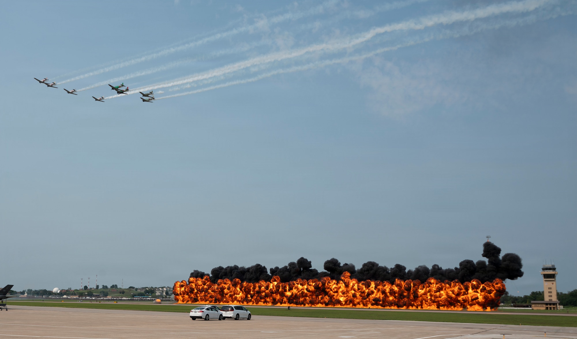 TORA! TORA! TORA! performs a synchronized flyover past a wall of pyrotechnic explosions at the 2026 Defenders of Freedom Air & Space Show at Offutt Air Force Base, Nebraska, Aug. 9, 2026. In alignment with the nationwide 'Freedom 250' celebration, the air show highlighted two and a half centuries of American progress, liberty, and the technological leaps made throughout military aviation history. (U.S. Air Force photo by Senior Airman Matthew Arachikavitz)