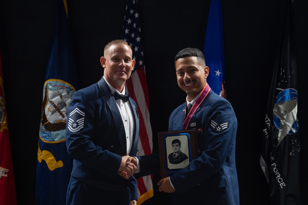 U.S. Air Force Senior Master Sgt. Darryl Parker, 17th Communications Squadron operations superintendent, presents Senior Airman Christian Del Mazo, 17th Security Forces Squadron defender, with the John Levitow Award, during the Airmen Leadership School Class 26-E graduation at Goodfellow Air Force Base, Texas, Aug. 6, 2026. The John Levitow Award is the highest honor awarded at professional military education courses, and it is presented to the student who achieves the highest overall combination of academic scores, performance evaluations and leadership qualities. (U.S. Air Force photo by Senior Airman Brian Lummus)