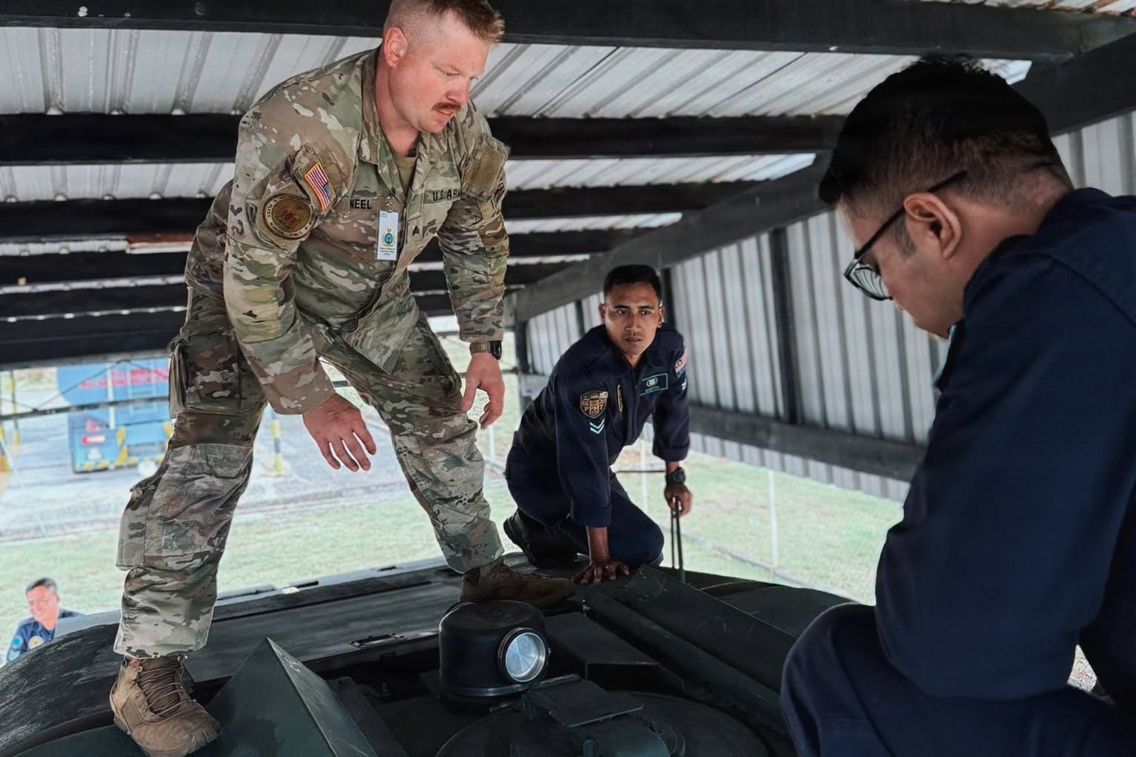 Sgt. Stavie Neel, petroleum supply specialist assigned to 181st Light Support Battalion, 81st Mobile Brigade Combat Team, Washington National Guard, talks with Royal Malaysian Air Force members during a Subject Matter Expert Exchange with a refueling team at Labuan Air Base, Malaysia, July 24-31, 2026
