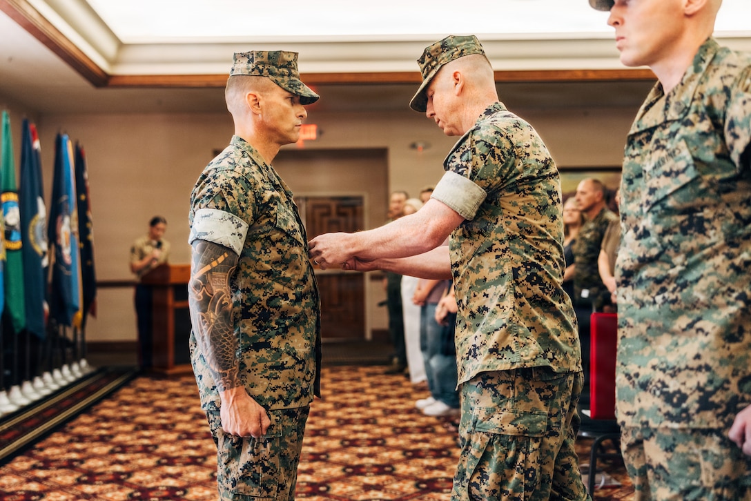U.S. Marine Corps Col. Phillip T. Ash, right, commanding officer of Marine Aviation Weapons and Tactics Squadron One (MAWTS-1), awards the Meritorious Service Medal to Sgt. Maj. David M. Potter, the outgoing sergeant major of MAWTS-1 during a relief and appointment ceremony at Marine Corps Air Station Yuma, Arizona, June 26, 2026. The historic post and relief ceremony is a time-honored tradition within the U.S. Marine Corps, allowing the new appointed Sergeant Major the opportunity to introduce himself to the Marines now under his charge. (U.S. Marine Corps photo by Cpl. Micah Thompson)
