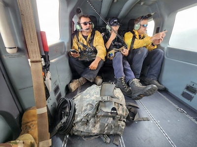 Washington State Department of Natural Resources firefighters "quarterback" from a Washington Army National Guard UH-72 Lakota helicopter about the Sinlahekin Fire in Okanogan County, Washington, Aug. 9, 2026.