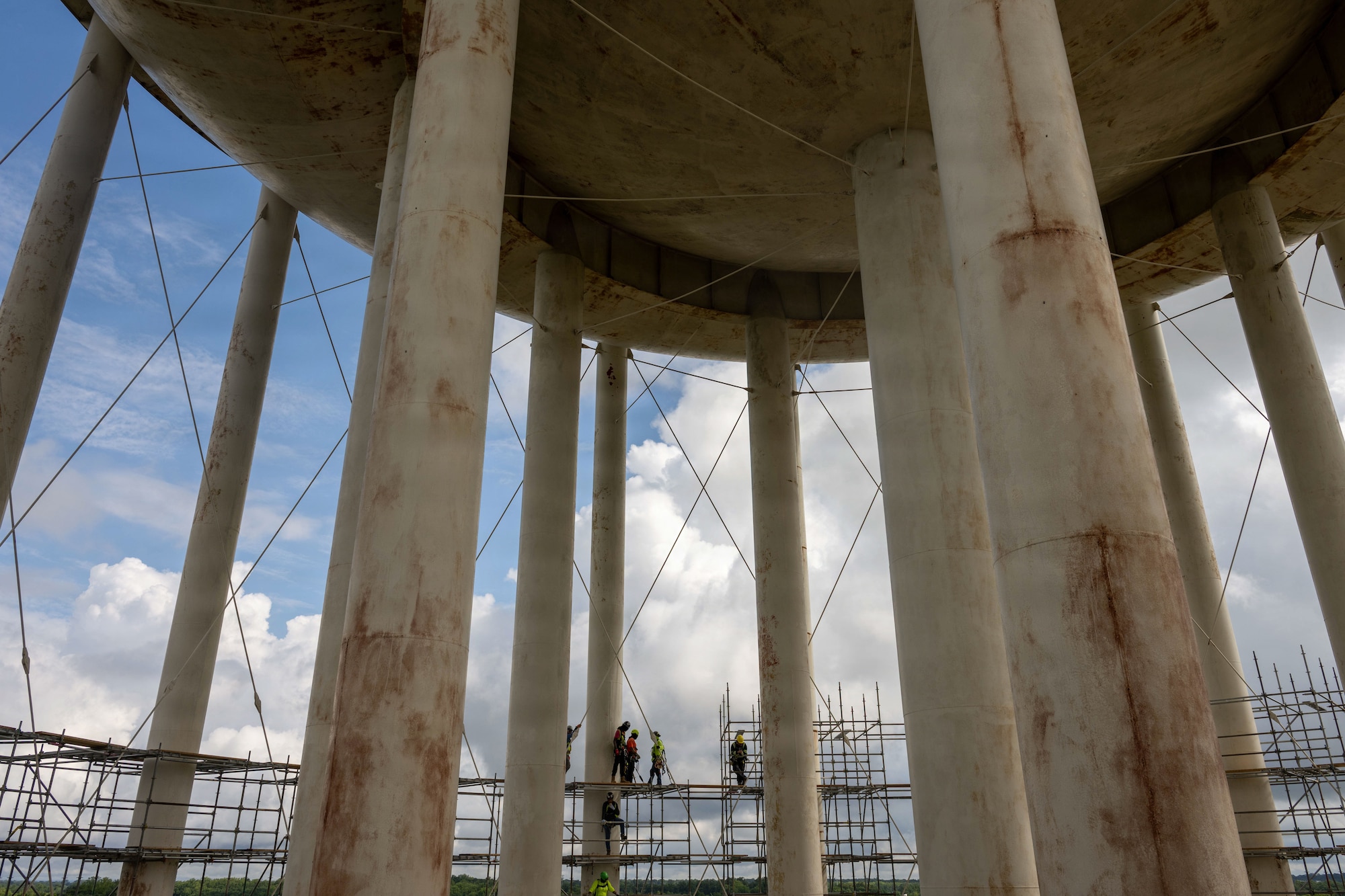 A group of men stand near the top of a water tower.