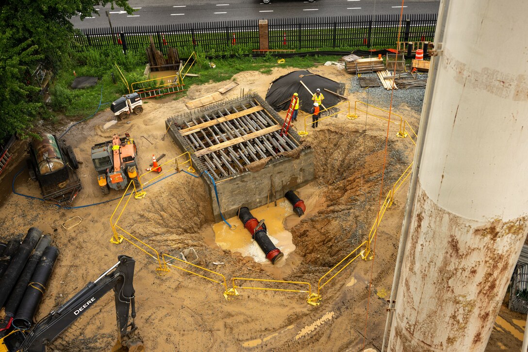 A car sized hole in the earth is filled with muddy water.