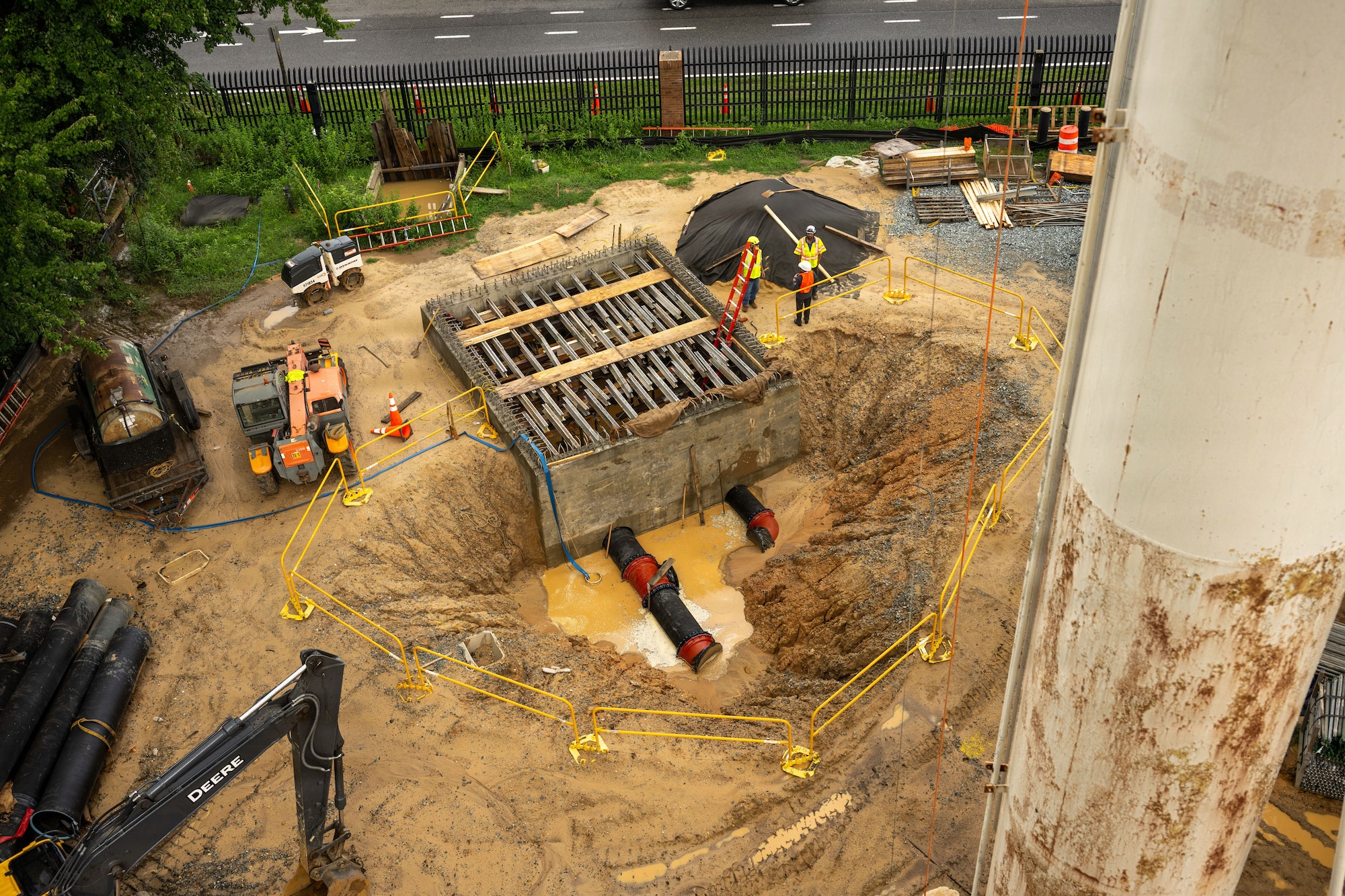 A car sized hole in the earth is filled with muddy water.