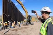 U.S. Army Corps of Engineers’ Mike Tuttle, a project manager assigned to the South Pacific Border Task Force, records the final panel installation at the National Defense Area One, or NDA-1, project site July 17 Antelope Wells, New Mexico. USACE is installing border barriers along the southern border of the U.S. at the direction of the U.S. Army by the Secretary of War, in response to the presidential national emergency declaration dated Jan. 20, 2025, authorizing the use of Section 2808 of Title 10, U.S. Code. (No one in this image crossed the international border)