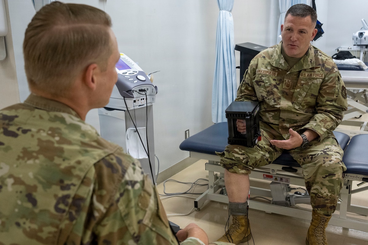 U.S. Air Force Staff Sgt. Keven Craig, left, a physical therapist assigned to the 35th Operational Medical Readiness Squadron, demonstrates rehabilitation equipment to Chief Master Sgt. Chief Master Sergeant Jason Amaxopulos, 35th Fighter Wing command chief, during a Wild Weasel Walkthrough at Misawa Air Base, Japan, Aug. 10, 2026.