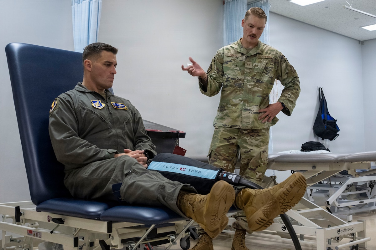 U.S. Air Force Staff Sgt. Keven Craig, right, a physical therapist assigned to the 35th Operational Medical Readiness Squadron, demonstrates a compression recovery system to Col. Oliver Lause, 35th Fighter Wing commander, during a Wild Weasel Walkthrough at Misawa Air Base, Japan, Aug. 10, 2026.