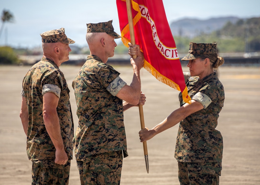 U.S. Marine Corps Sgt. Maj. Joy M. Kitashima, right, the command senior enlisted leader of U.S. Marine Corps Forces, Pacific, delivers the unit colors to Lt. Gen. James F. Glynn, the outgoing commander of U.S. Marine Corps Forces, Pacific, during the MARFORPAC change of command ceremony at Marine Corps Air Station Kaneohe Bay, Hawaii, Aug. 11, 2026. Representing two-thirds of the Marine Corps’ operating forces, MARFORPAC serves as the nation’s primary expeditionary force-in-readiness across the U.S. Pacific Command area of responsibility, the largest geographic combatant command in the Department of War, where Pacific Marines operate alongside joint forces and international partners to preserve a free and open Pacific. (U.S. Marine Corps photo by Lance Cpl. Jose Villasenor)