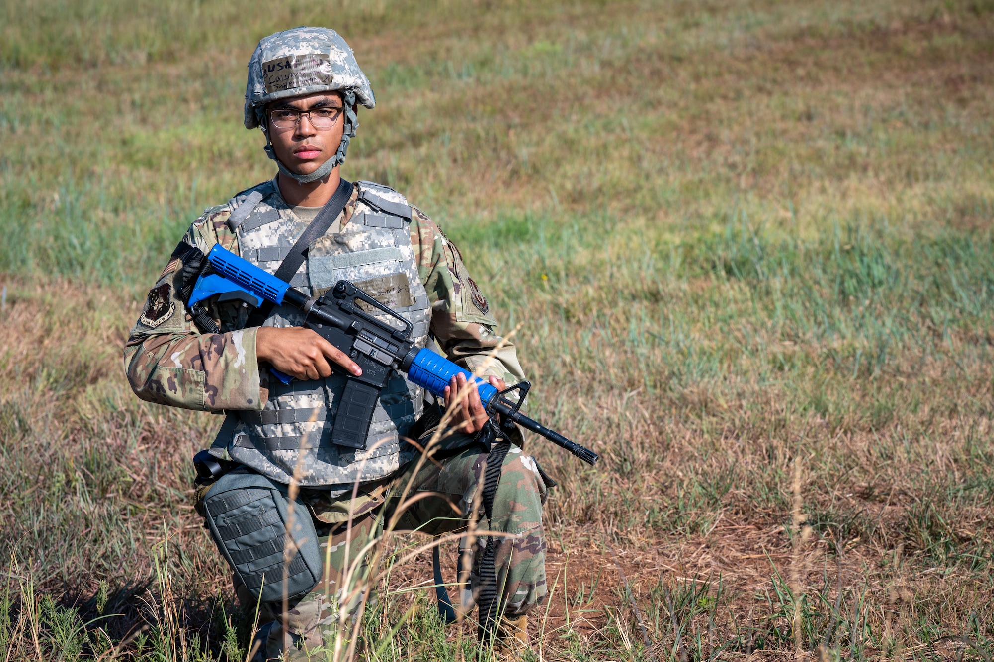 Airman kneeling in field