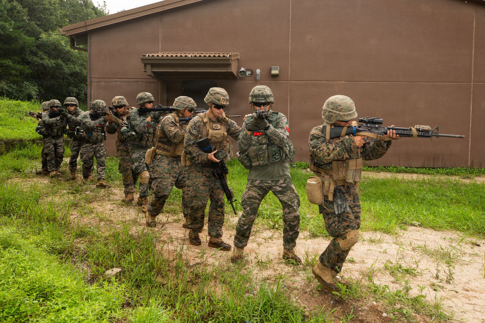 U.S. Marines with 9th Engineer Support Battalion, 3rd Marine Logistics Group, and members of the Republic of Korea Marine Corps maneuver toward a building during bilateral breaching training at Rodriguez Live Fire Complex, South Korea, July 28, 2026.