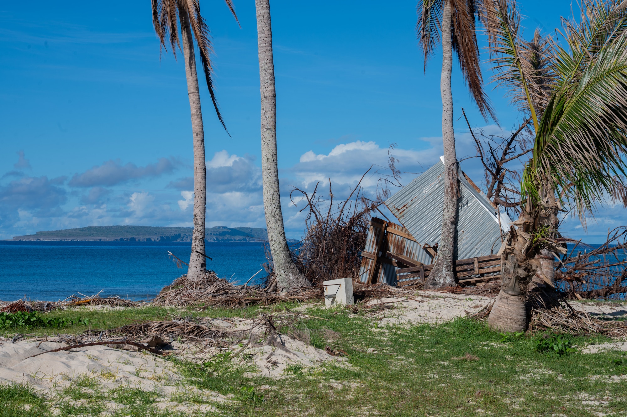Debris left behind by Typhoon Sinlaku litters a field on Tinian, Commonwealth of the Northern Mariana Islands, June 9, 2026. Members of the 21st Combat Air Base Squadron supported disaster recovery efforts by the Federal Emergency Management Agency following major infrastructure damage from the storm. The Department of War plays a vital role in disaster response, coordinating closely with federal, territorial and local civil authorities to restore essential services and build community trust. (U.S. Air Force photo by Senior Airman Alondra Cristobal)