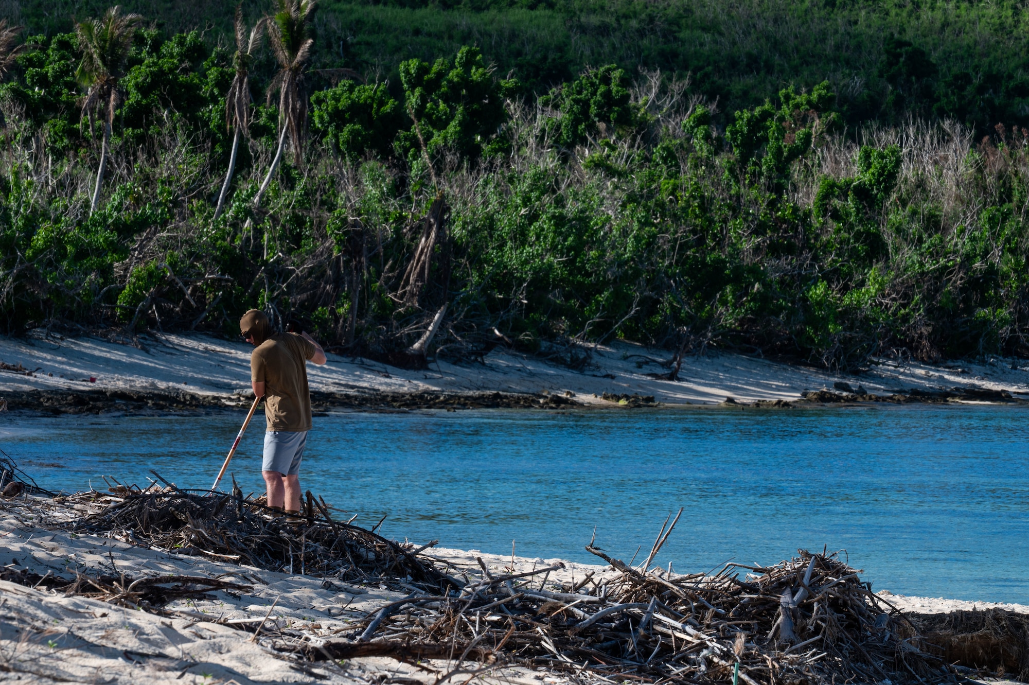 U.S. Air Force Senior Airman Evan Bland, 21st Combat Air Base Squadron vehicle mechanic, clears storm debris from a local park on Tinian, Commonwealth of the Northern Mariana Islands, June 11, 2026. The 21st CABS utilized multi-skilled, Mission-Ready Airmen to execute cross-functional tasks, restoring vital public spaces in the CNMI following Typhoon Sinlaku. The Department of War remains committed to supporting civil authorities, working in close coordination with the Federal Emergency Management Agency and local territorial officials to deliver a unified response. (U.S. Air Force photo by Senior Airman Alondra Cristobal)
