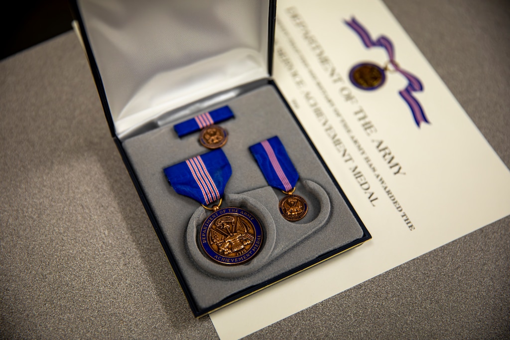 A Department of the Army Civilian Service Achievement Medal and certificate are prepared for an upcoming awards presentation.