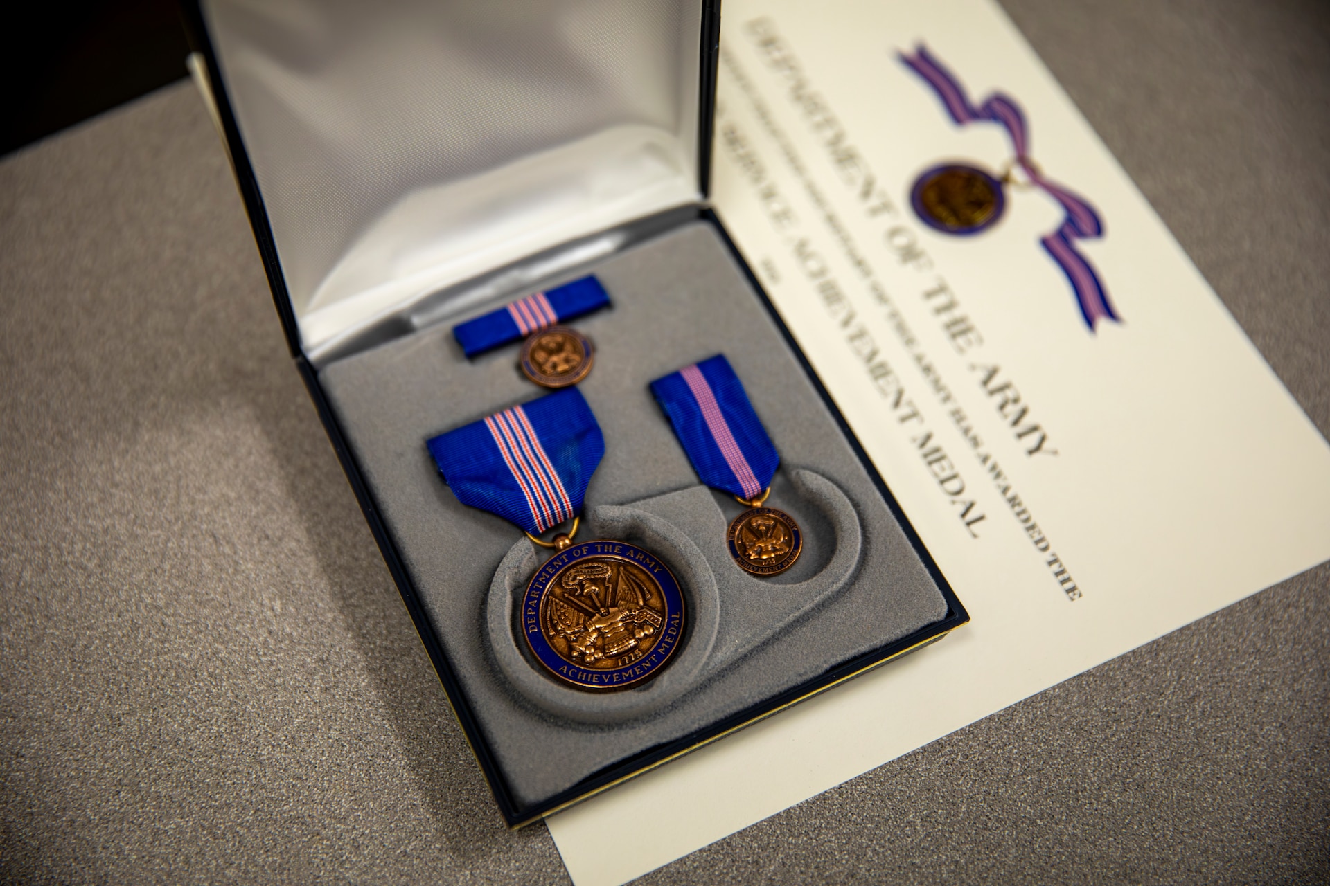 A Department of the Army Civilian Service Achievement Medal and certificate are prepared for an upcoming awards presentation.