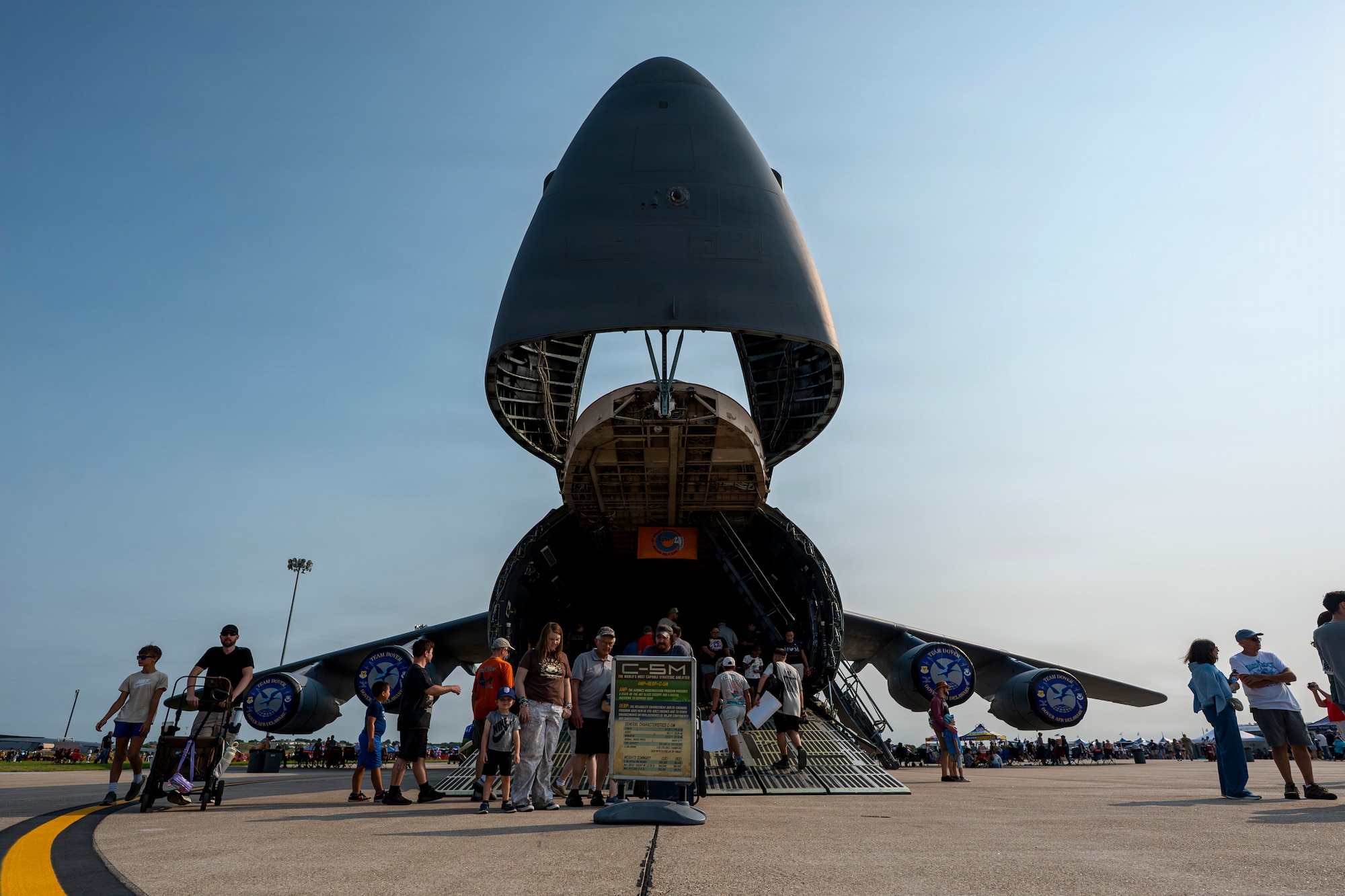 A C-5M Super Galaxy heavy transport aircraft is parked on the flightline as visitors explore its cargo bay during the 2026 Defenders of Freedom Air & Space Show at Offutt Air Force Base, Nebraska, Aug. 8, 2026. The open house provided a rare opportunity for local Greater Omaha residents to interact directly with service members, ask questions, and explore the military aircraft that make the nation's global defense possible. (U.S. Air Force photo by Senior Airman Matthew Arachikavitz)