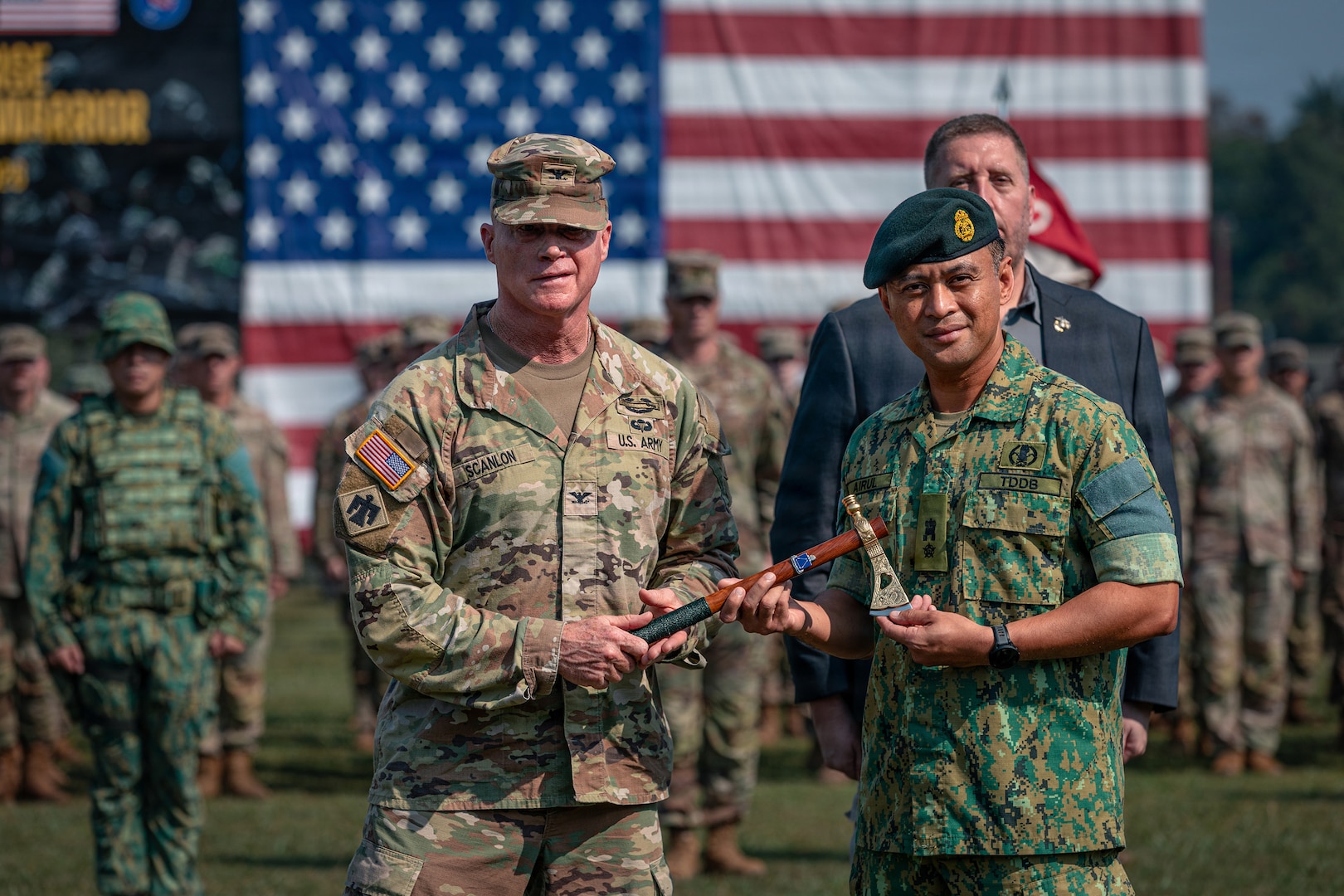 U.S. Army Col. Michael Scanlon, deputy chief of staff for operations, Oklahoma Army National Guard, left, presents a gift to Lt. Col. Haji Mohammad Airul Wizam bin Haji Ahmad, deputy field commander of the Royal Brunei Land Force, right, during the opening ceremony for Exercise Pahlawan Warrior at Tutong Camp near Bandar Seri Begawan, Aug. 11, 2026.