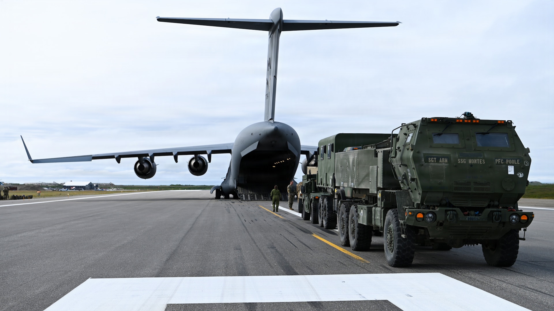 A U.S. Army M142 High Mobility Artillery Rocket System, assigned to 17th Long Range Fires and Effects Brigade, waits on the flightline before being loaded into a Royal Canadian Air Force C-17 Globemaster III aircraft in Nome, Alaska, Aug. 11, 2026. The HIMARS was deployed to the Arctic from Joint Base Lewis-McChord in support of Operation TUNDRA MERLIN, showcasing U.S. and Canadian forces' ability to rapidly move combat equipment and personnel across the Arctic. (U.S. Air Force photo by Senior Airman Gabriel Held)