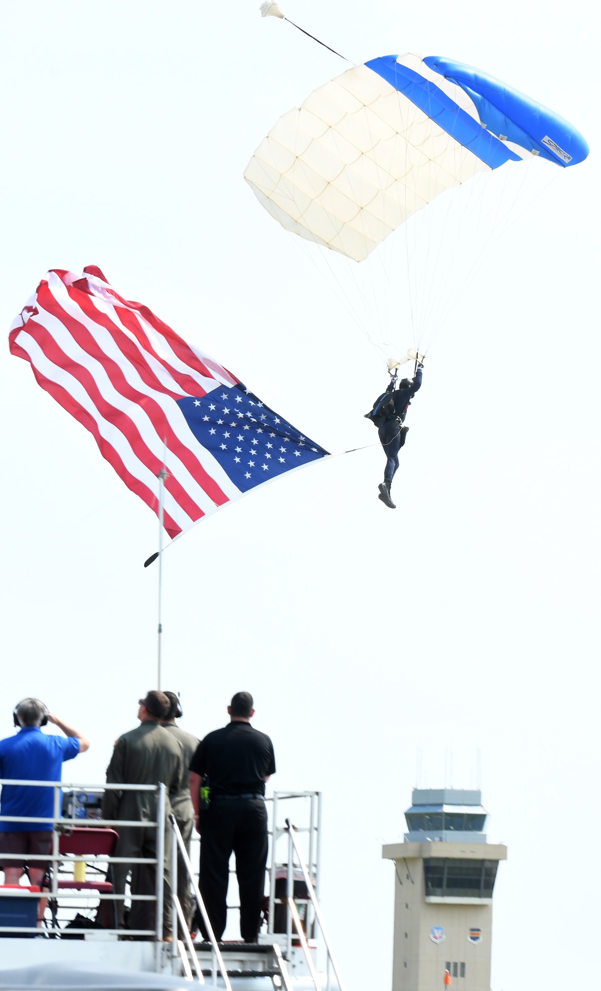 A U.S. Air Force Academy Wings of Blue parachuting team member prepares to land with an America flag during the Defenders of Freedom Air & Space Show 2026 at Offutt Air Force Base, Nebraska, Aug. 8, 2026. In alignment with the nationwide 'Freedom 250' celebration, the air show highlighted two-and-a-half centuries of American progress, liberty, and the technological leaps made throughout military aviation history. (U.S. Air Force photo by Charles J. Haymond)