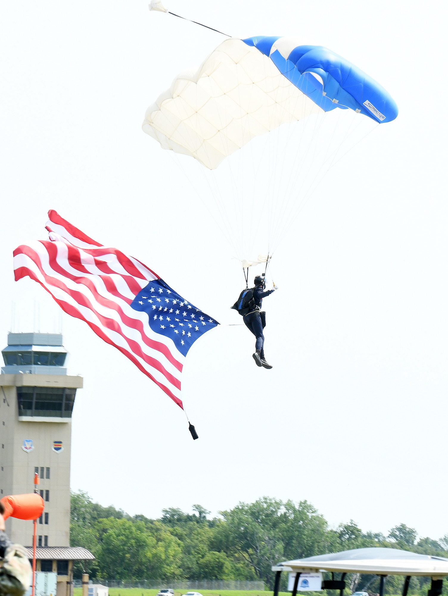 A U.S. Air Force Academy Wings of Blue parachuting team member prepares to land with an America flag during the Defenders of Freedom Air & Space Show 2026 at Offutt Air Force Base, Nebraska, Aug. 8, 2026. In alignment with the nationwide 'Freedom 250' celebration, the air show highlighted two-and-a-half centuries of American progress, liberty, and the technological leaps made throughout military aviation history. (U.S. Air Force photo by Charles J. Haymond)