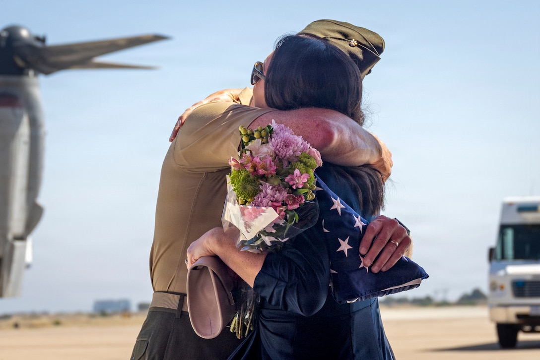 U.S. Marine Corps Lt. Col. Wilbur Oles, the operations officer of Marine Corps Station Miramar, embraces his wife during his retirement ceremony at MCAS Miramar, California, May 8, 2026. Oles retired after 22 years of honorable and dedicated service in the Marine Corps. (U.S. Marine Corps photo by Cpl. Seferino Gamez)