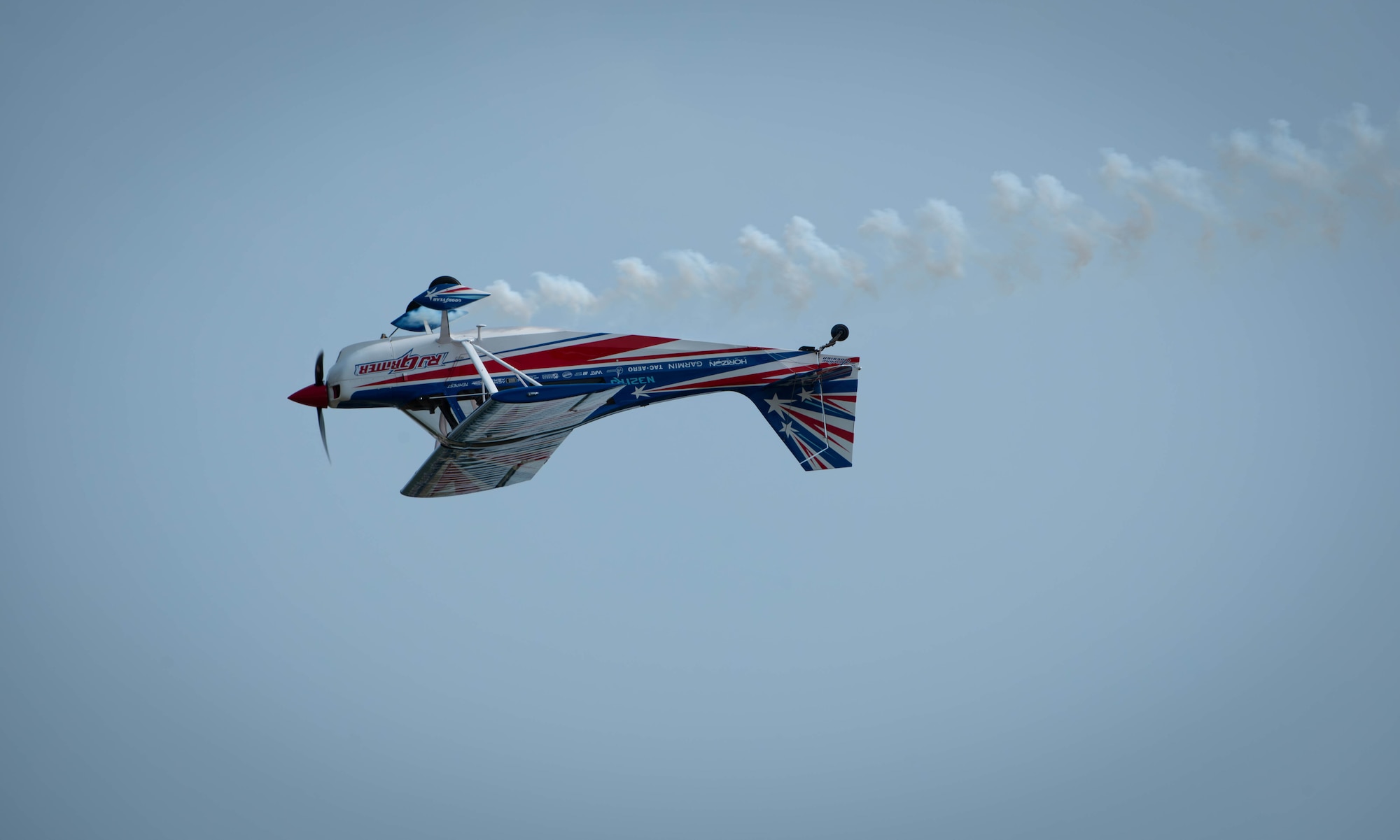A Red Bull Air Force aircraft executes a high-energy aerial stunt display over the flightline during the 2026 Defenders of Freedom Air & Space Show at Offutt Air Force Base, Nebraska, Aug. 9, 2026. Defenders of Freedom Air & Space Show 2026 served as a free, public open house to foster strong community relations and express appreciation to the local Greater Omaha community. (U.S. Air Force photo by Daniel Martinez)