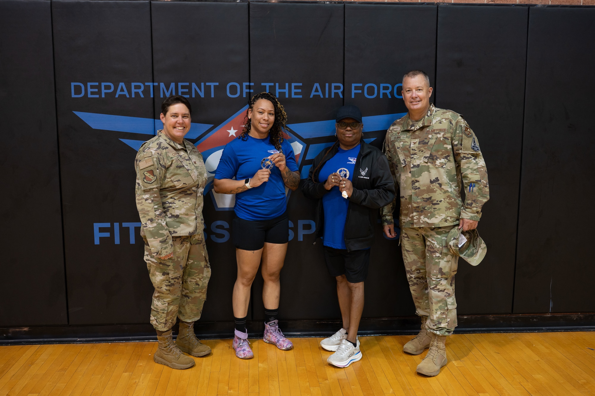 Tierra Taylor, center left, lead fitness testing technician for Joint Base Anacostia-Bolling Fitness Center, and Desiree Taylor-Lilley, center right, recreation assistant for JBAB Fitness Center, receive challenge coins from U.S. Air Force Col. James M. Clark, far right, commander of the 11th Wing and JBAB, and Col. Rebecca Corbin, far left, deputy commander of the 11th Wing and JBAB.