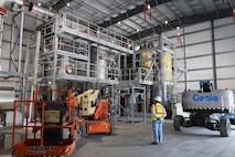 An engineer looks at a machine that cleans the air.