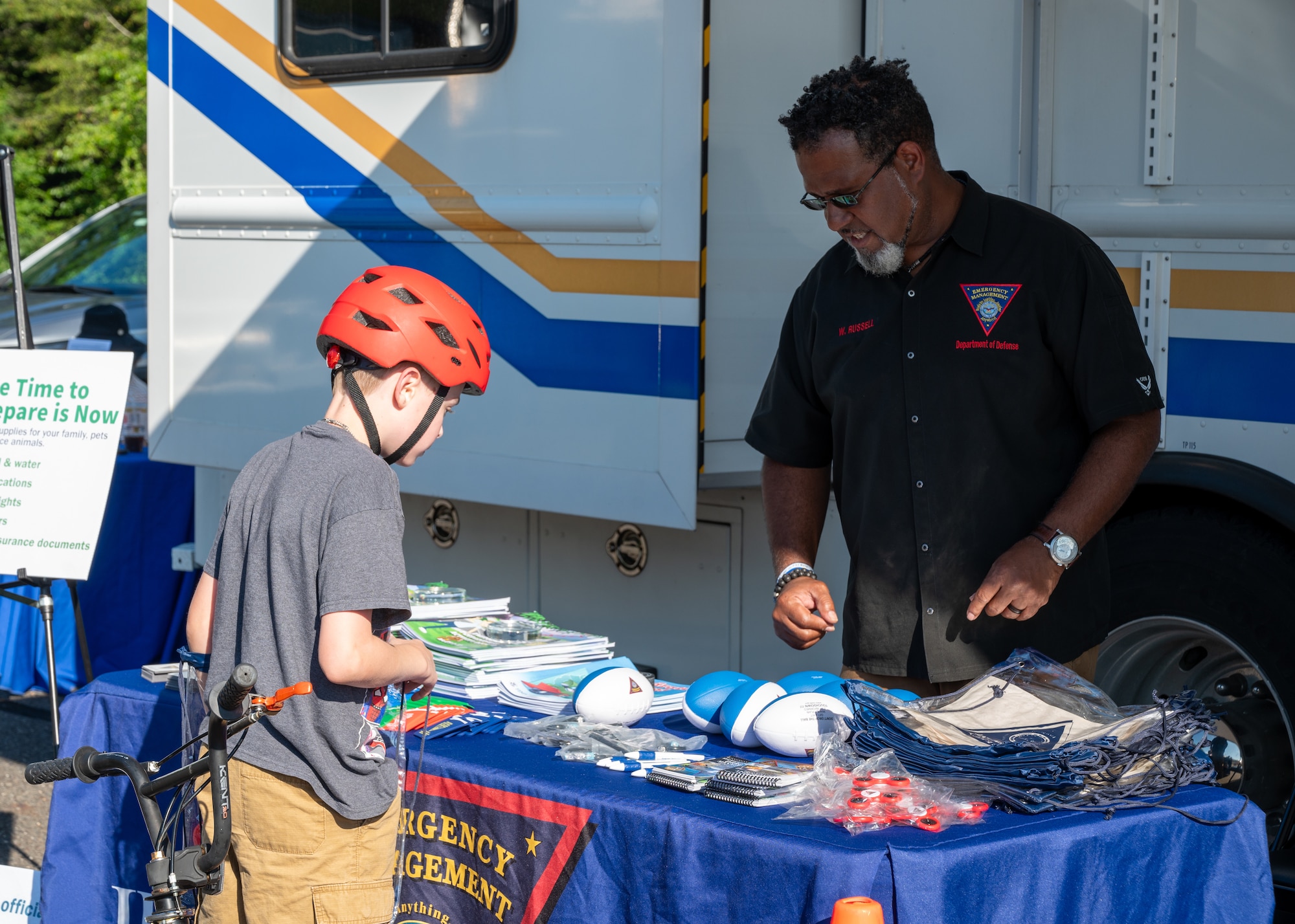 Tech. Sgt. Keith Neal, 87th Security Forces Squadron training noncommissioned officer in charge, supervises a child using a training baton to hit a simulated opponent during National Night Out at Joint Base McGuire-Dix-Lakehurst, N.J., Aug. 4, 2026.