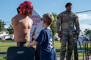 Wayne Russell, 87th Civil Engineer Squadron Emergency Management deputy, talks with a child at the 87th CES Emergency Management table during National Night Out at Joint Base McGuire-Dix-Lakehurst, N.J., Aug. 4, 2026.