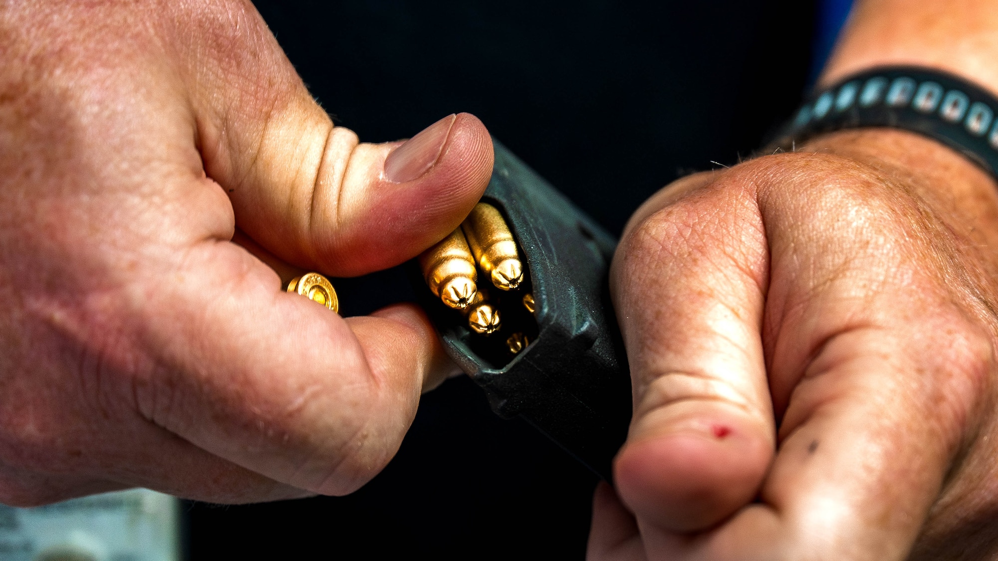 A photo of a man reloading ammunition.