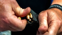 A photo of a man reloading ammunition.