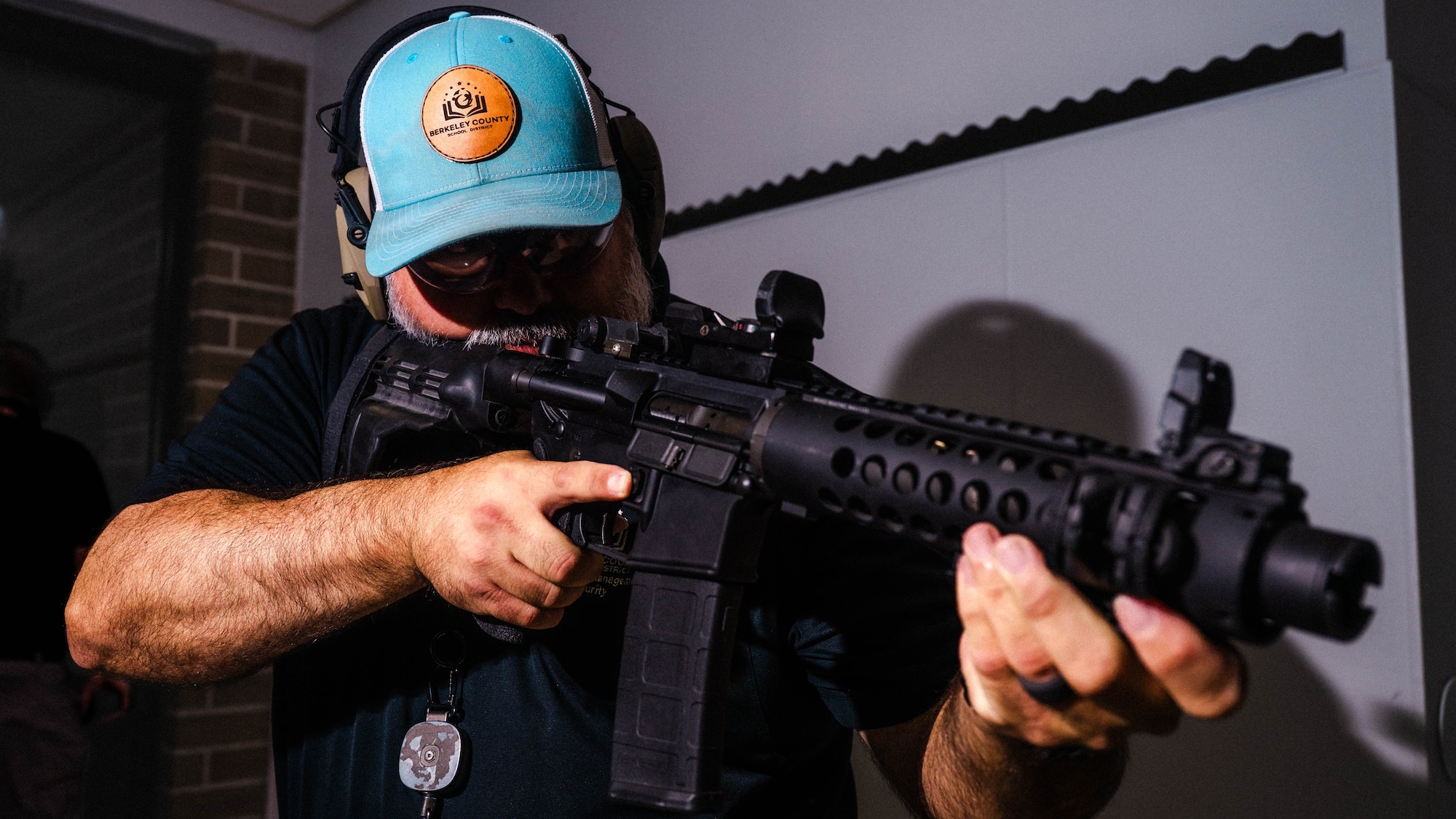 A photo of a man in a hallway holding an M4 rifle.